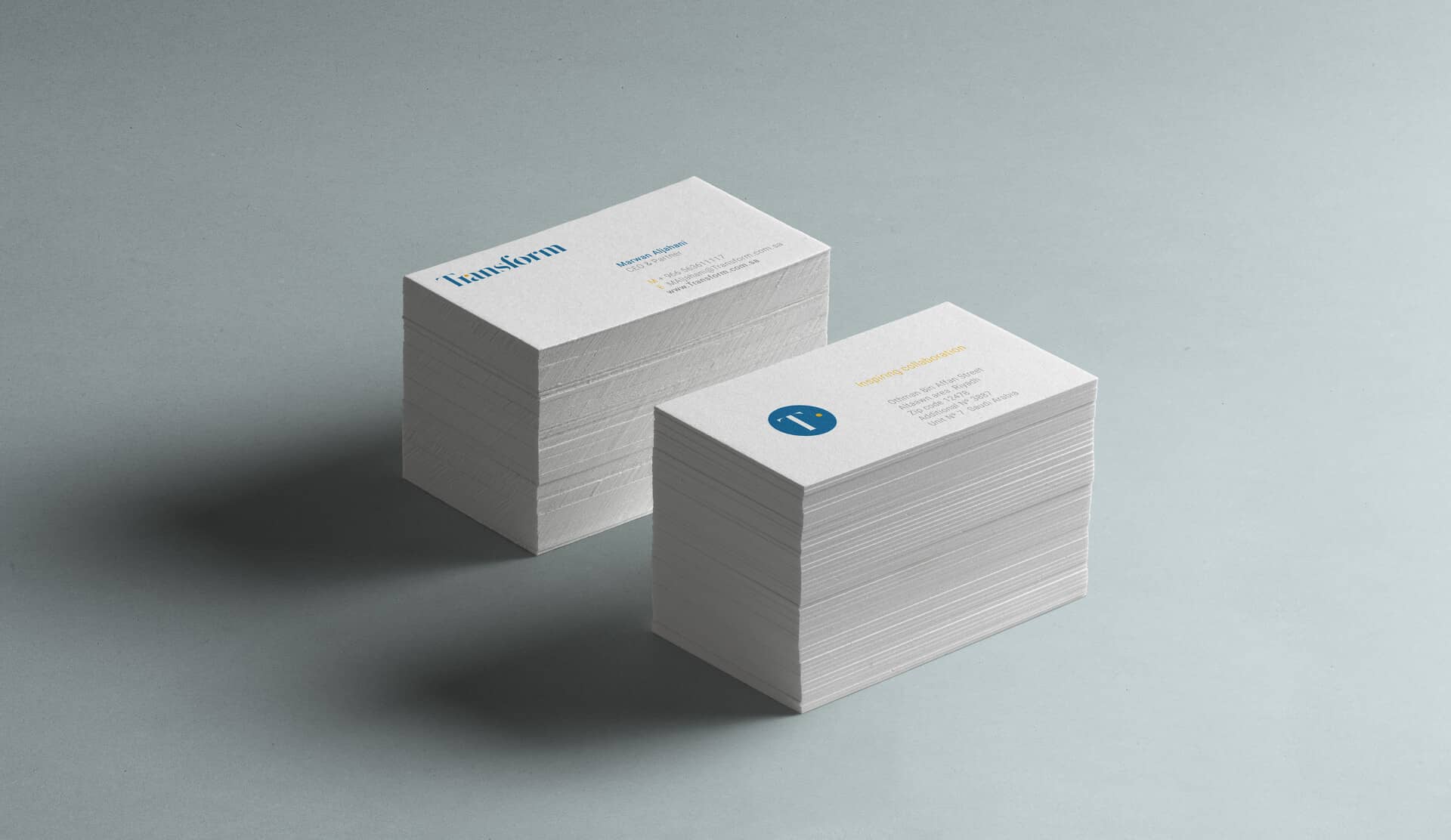 Two piles showing the two sides of Transform's business cards